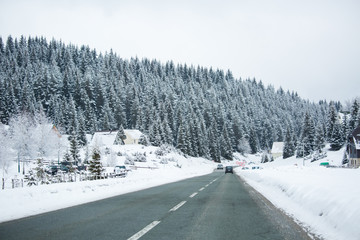 Mountain winter road goes through the village