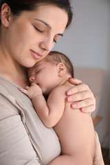 Young mother with cute baby at home