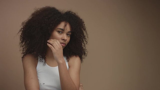 portrait of black mixed race model in studio in beige background. Natural look