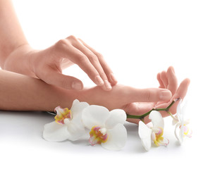 Young woman touching her hand and feeling moisturizing effect of cream on white background