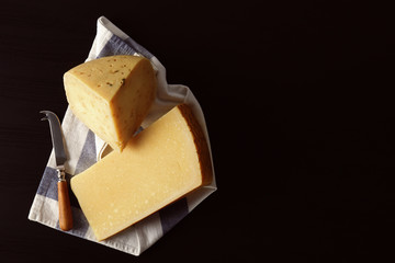 Different kinds of delicious cheese on dark background
