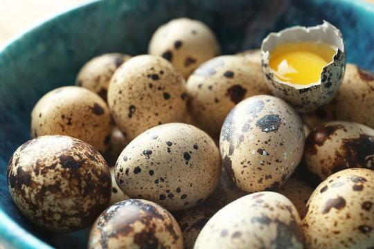 Raw quail eggs in bowl, closeup