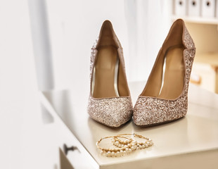 Pair of sparkly female shoes on dresser