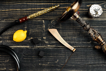 Dismantled parts of hookah on a wooden background with lemon fru