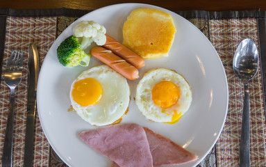 American breakfast with sunny side up eggs, bacon, toast, pancakes
