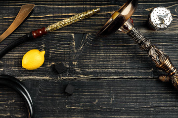 Dismantled parts of hookah on a wooden background with lemon fru