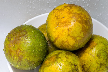 Fresh oranges on a white ceramic plate