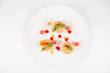 Plum dumplings with cinnamon, white chocolate and vanilla sauce on a white background