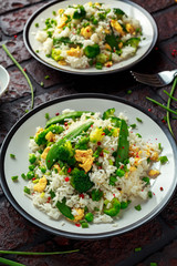 Fried rice with vegetables, broccoli, peas and eggs in a plate. healthy food