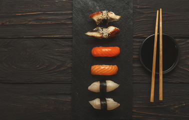 Set of sushi on black wood background, top view
