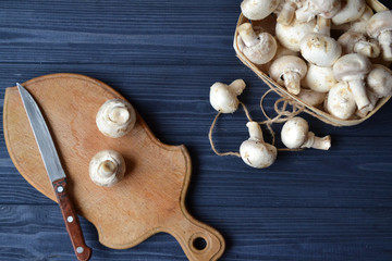 Mushrooms on the dark blue wooden desk. Cooking champignons.