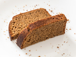 Two piece of black rye bread on white background