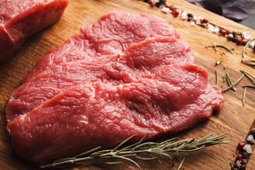Raw beef filet mignon steaks on wooden board