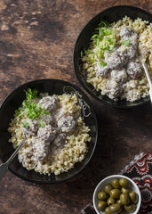 Lamb meatballs in a yogurt sauce and bulgur - delicious healthy lunch in a mediterranean style on a wooden background, top view
