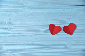 Red hearts on blue wooden background.