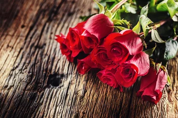 Tuinposter Red Roses. Bouquet of red roses free lying on rustic oak table © weyo