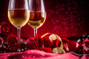 Valentines or wedding concept. Wine cups red roses and romantic setting for two in red. Greeting card for jubilee or aniversary