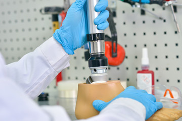 Close up shot of unrecognizable prosthetics technician  assembling prosthetic leg in modern ...