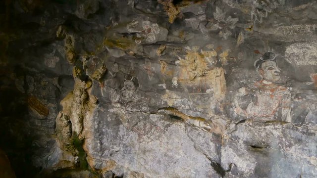 Historic painting in sandstone cave. Spotlight on historical art on the wall.