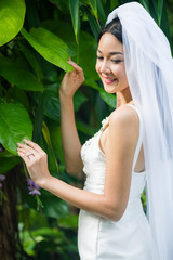 The bride take photo with a ring in the garden.