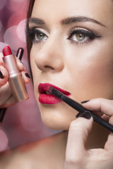 woman applying red lipstick with brush .make up  beauty