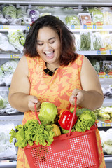 Fat woman carrying organic vegetables