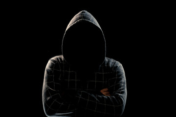 Portrait, silhouette of a man in a hood on a black background, his face is not visible. The concept...