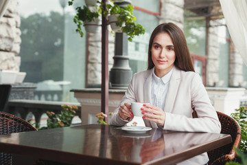 Young businesswoman outdoors drinking coffee