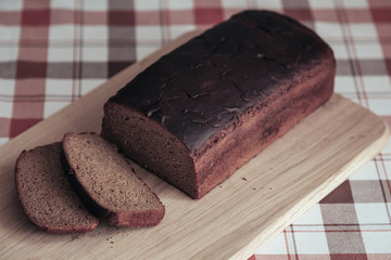 Freshly Baked Bread Slice On Wooden Cutting Board On Plaid Tablecloth, Close Up