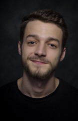 Fototapeta premium Portrait of a young man with a beard on a dark background.