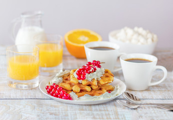 Romantic breakfast with Belgian waffles, honey, red currant, coffee, marshmallow and fresh orange juice