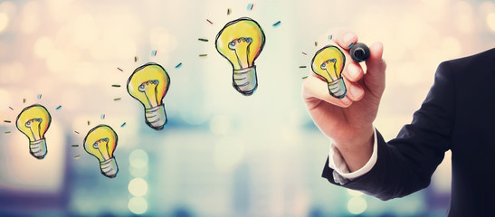 Light Bulbs with businessman on blurred abstract background © Tierney