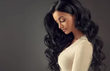 Photo sur Plexiglas Salon de coiffure Fille brune aux cheveux ondulés longs et brillants. Belle femme modèle avec une coiffure frisée.