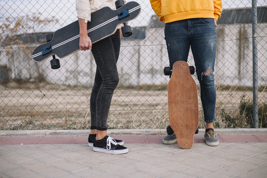 Two girls who play in the street with longboard