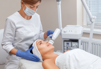 The doctor-cosmetologist makes the apparatus a procedure of Hardware face cleaning with a soft...