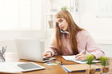 Serious business woman at work talking on phone