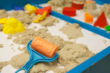 Plastic Mold toys with sand on sandbox. Background blurry.