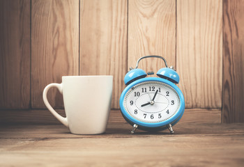 Alarm clock and coffee cup on the desk.