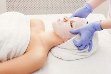 Woman gets face mask by beautician at spa
