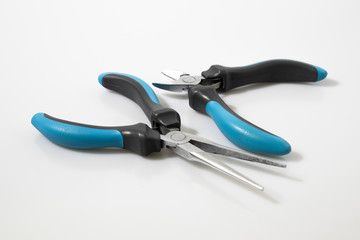 Obraz premium Blue flat-nose pliers in a white background composition