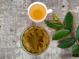 Healthy guava tea brewing in a bowl and cup of tea on the wooden table