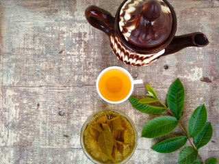 Healthy guava tea brewing in a bowl and cup of tea on the wooden table 