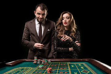 Man and woman playing at roulette table in casino