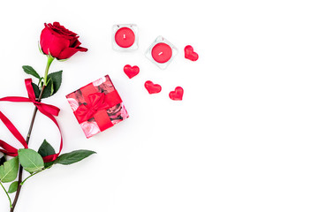 Gift for Valentine's day. Red rose, gift box, red hearts signs on white background top view copy space