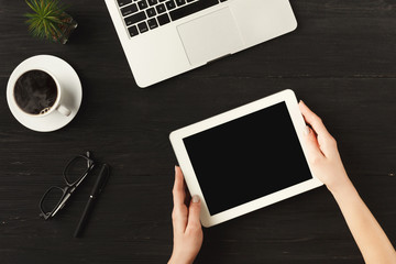 Woman's hands on digital tablet, top view