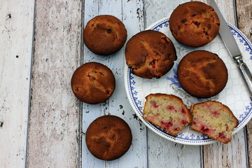 Red currant muffins with antique looking blue plate on wooden background