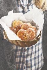 Female hands holding a doughnut shaped of heart, Valentines day and love theme