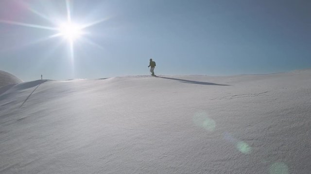 hiker walking on fresh powder snow hiking a mountain slope aerial view 