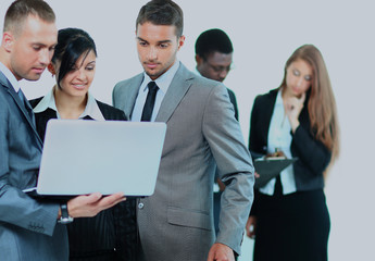 Portrait of business team working on laptop together.