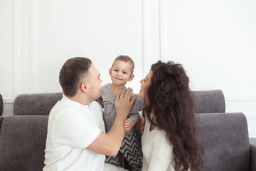 Young happy family, parenthood and people concept. Mother, father and child son at home spending time together